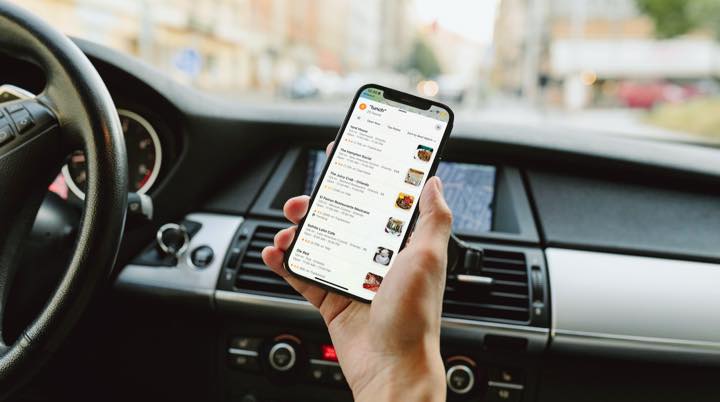 Guest searching restaurant reviews on a phone before choosing where to order.